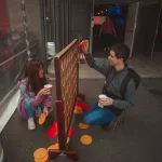 Friends play a game outside the auditorium (thumbnail)